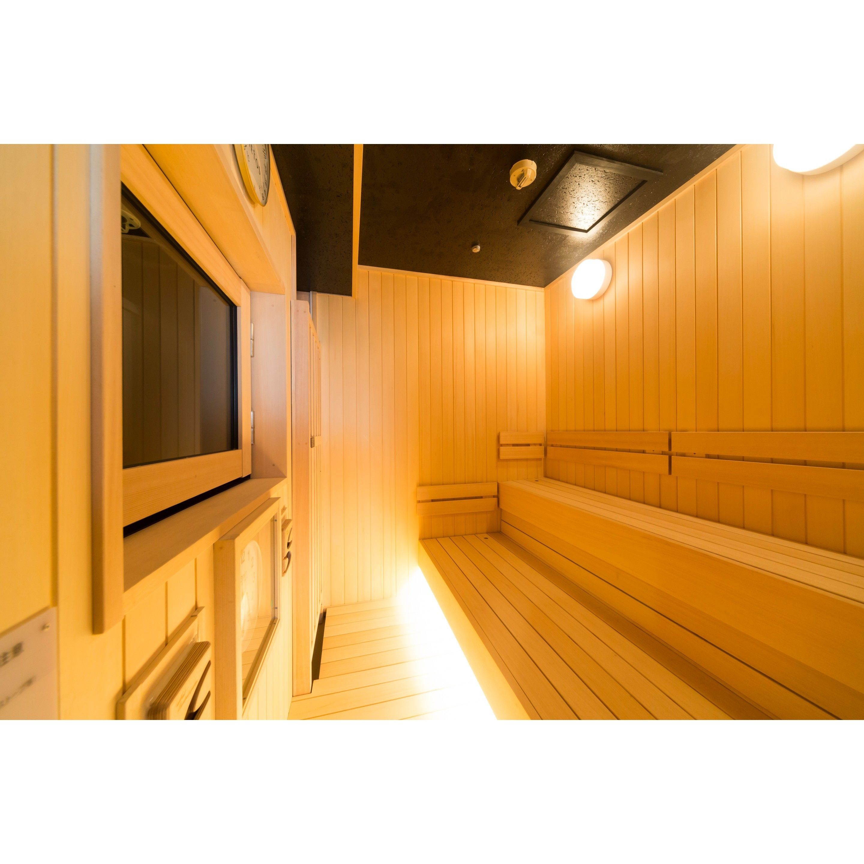Un sauna con bancos de madera y un televisor.