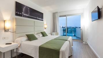 A hotel room with two beds, a large window with a view, a flat-screen TV, and a painting of lightning on the wall.