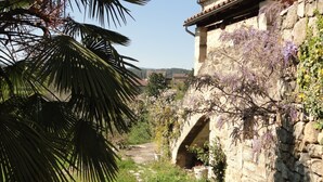 Un bâtiment en pierre, doté d’un mur en pierre rustique et d’une petite arche.