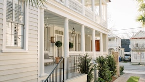 A two-story house with a covered porch, a staircase, and a well-maintained lawn. - 86 Cannon Charleston - Adults Only (Charleston)