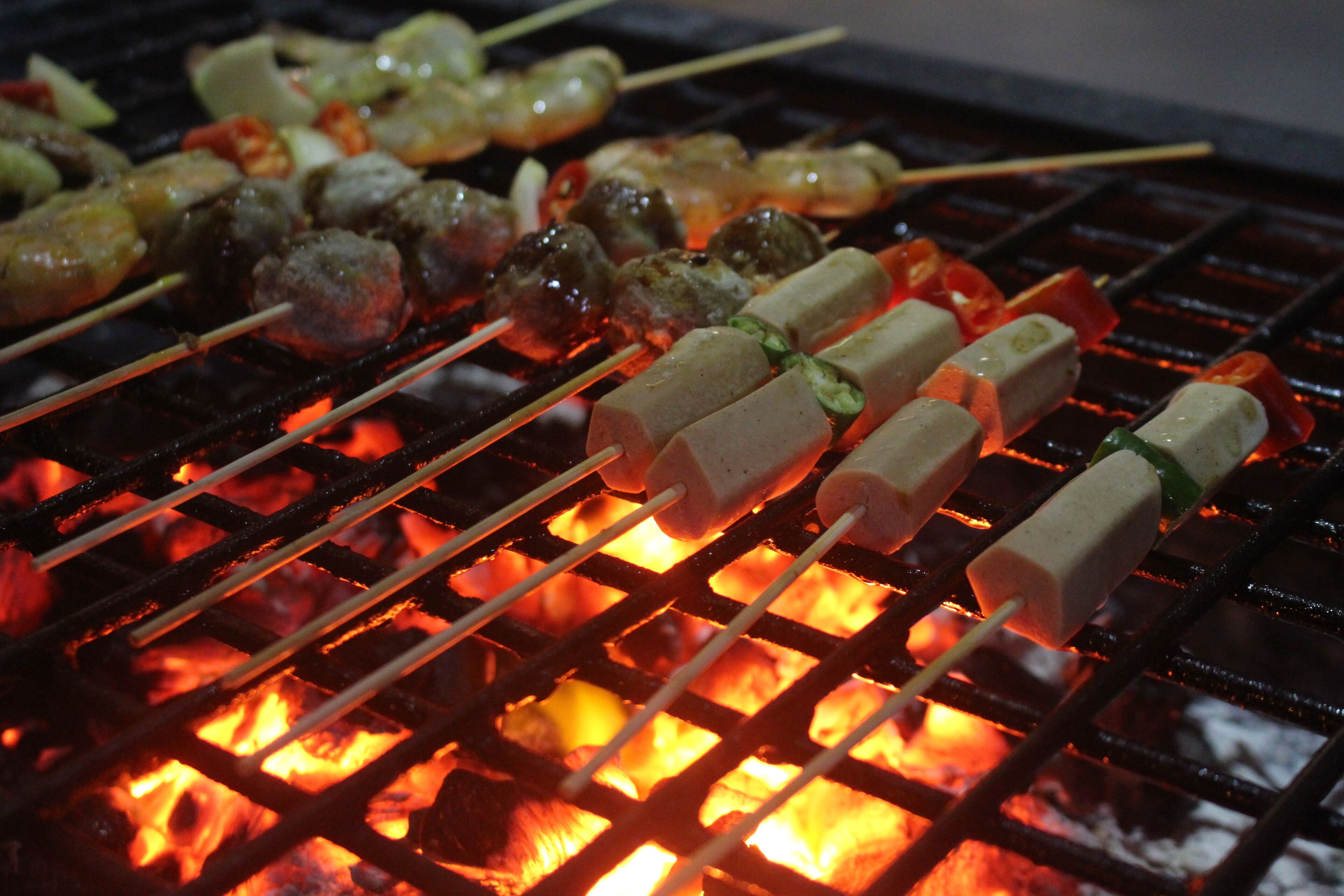 A grill with skewers of meat and vegetables.