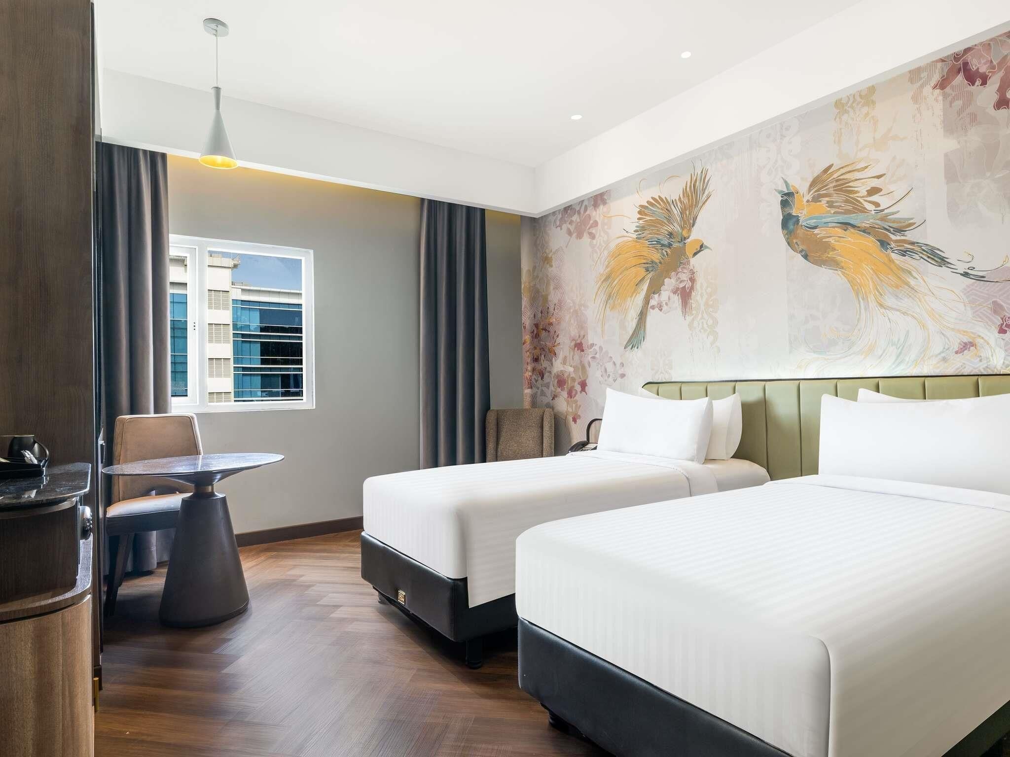 Habitación de hotel con dos camas, una mesa de comedor, una silla, un sofá y un ventanal grande.