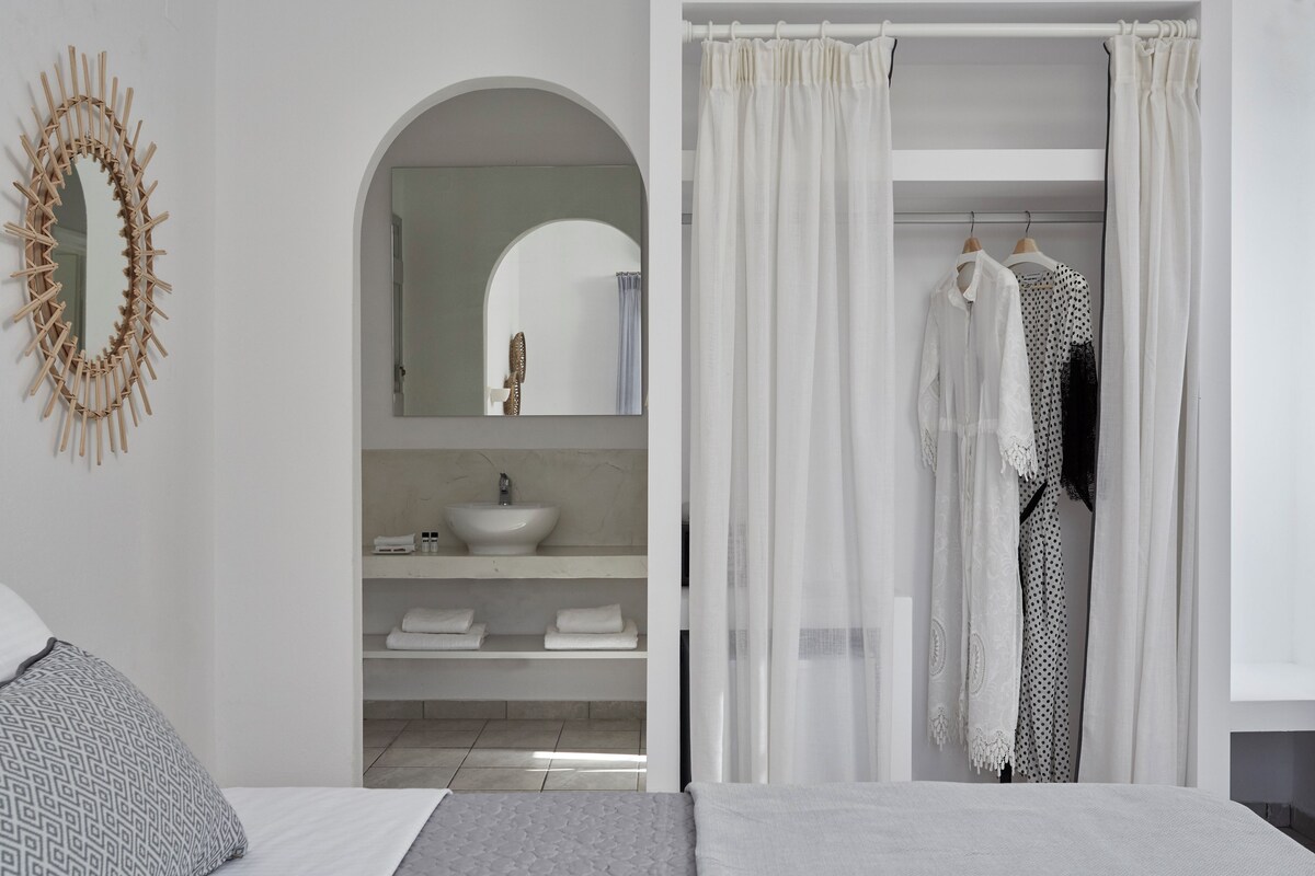 A modern bathroom with a freestanding sink, a mirror, and a shower curtain.