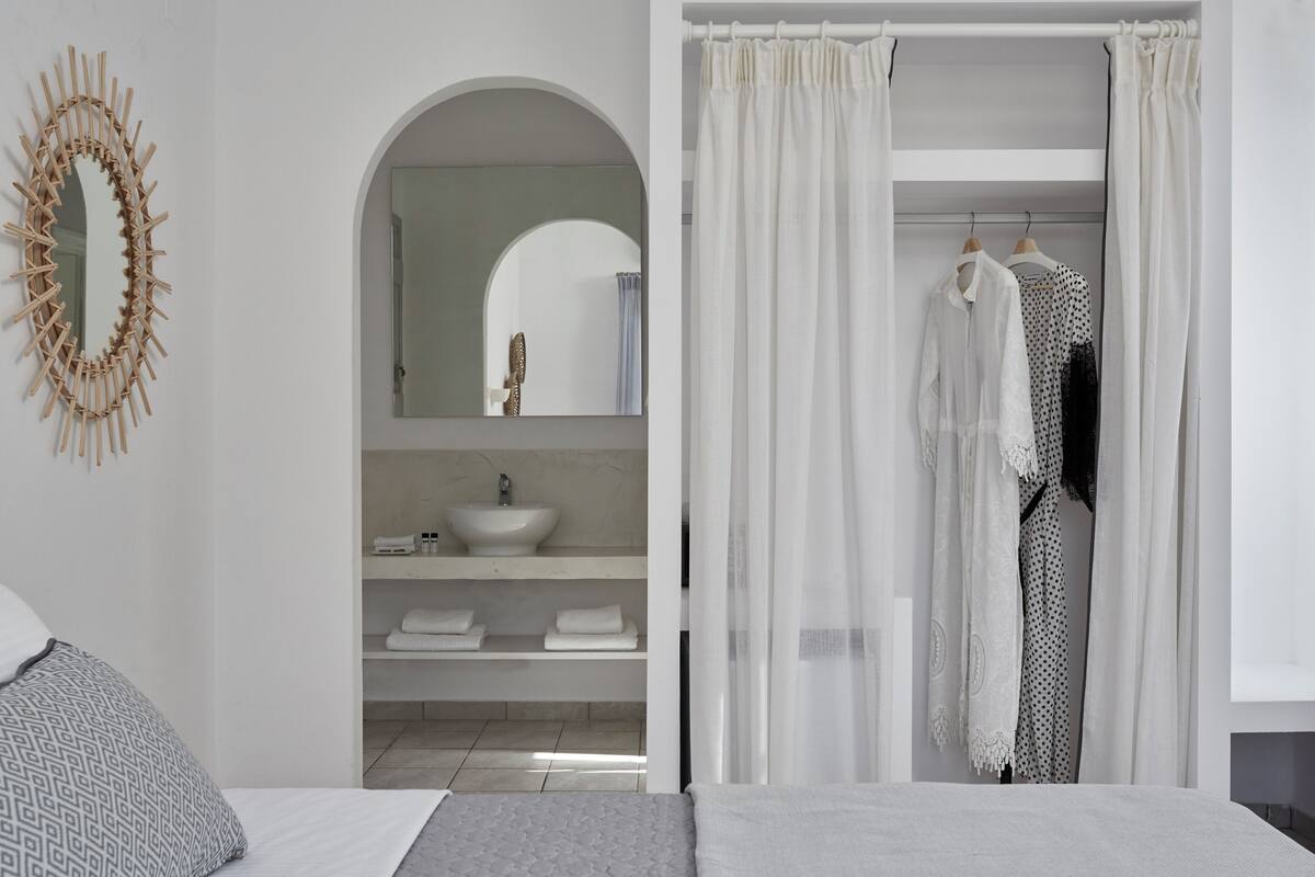 Une salle de bain moderne avec un lavabo sur pied, un miroir et un rideau de douche.