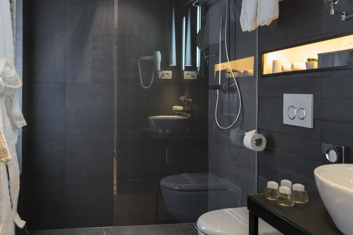 junior suite, 1 king bed, hot tub, city view | bathroom | free toiletries, hair dryer, slippers, towels