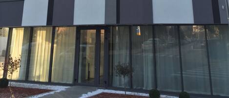 Un edificio de varios pisos con un diseño arquitectónico moderno, con grandes ventanales y techo plano.