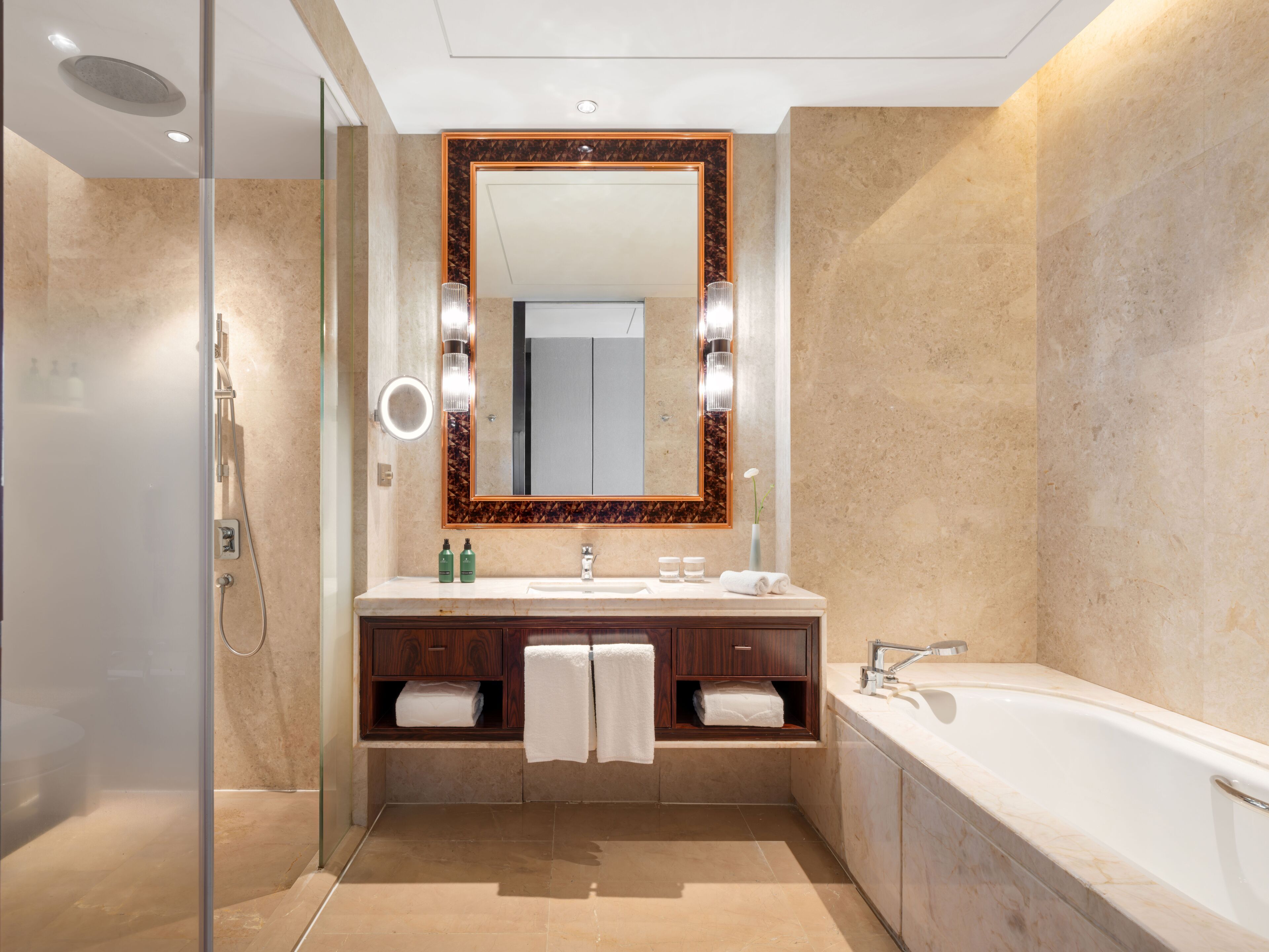 A modern bathroom with a large mirror, a bathtub, and a shower area.