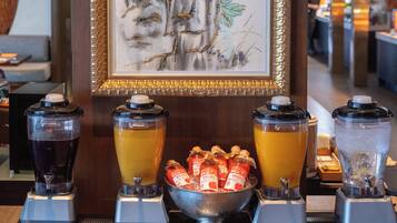Una zona de bar con tres dispensadores de bebidas, un bol de aperitivos y una obra de arte enmarcada en la pared.