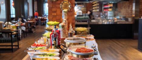 A buffet setup with various food items and utensils.
