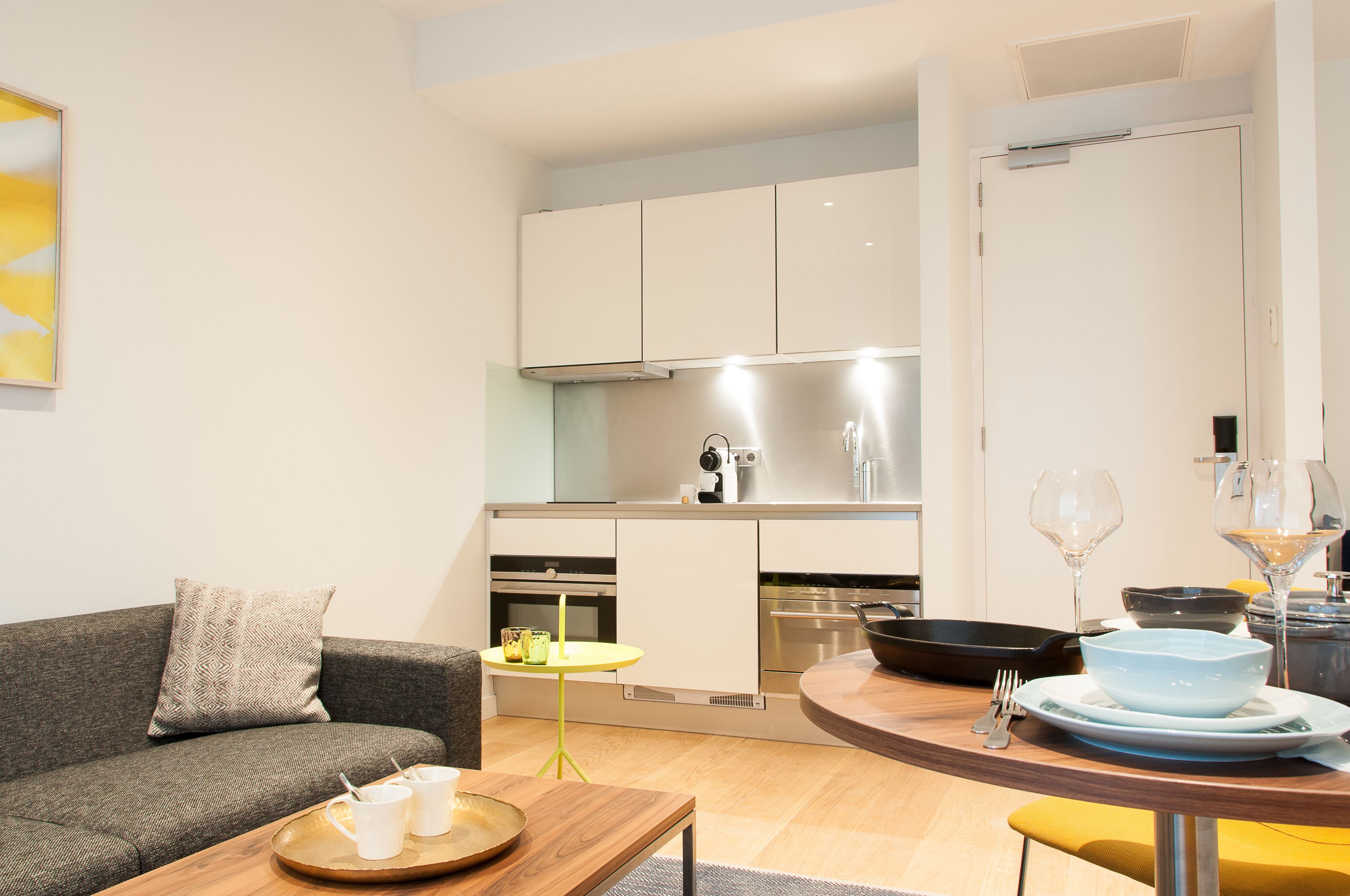 A modern apartment with a living area, a dining table, and a kitchen.