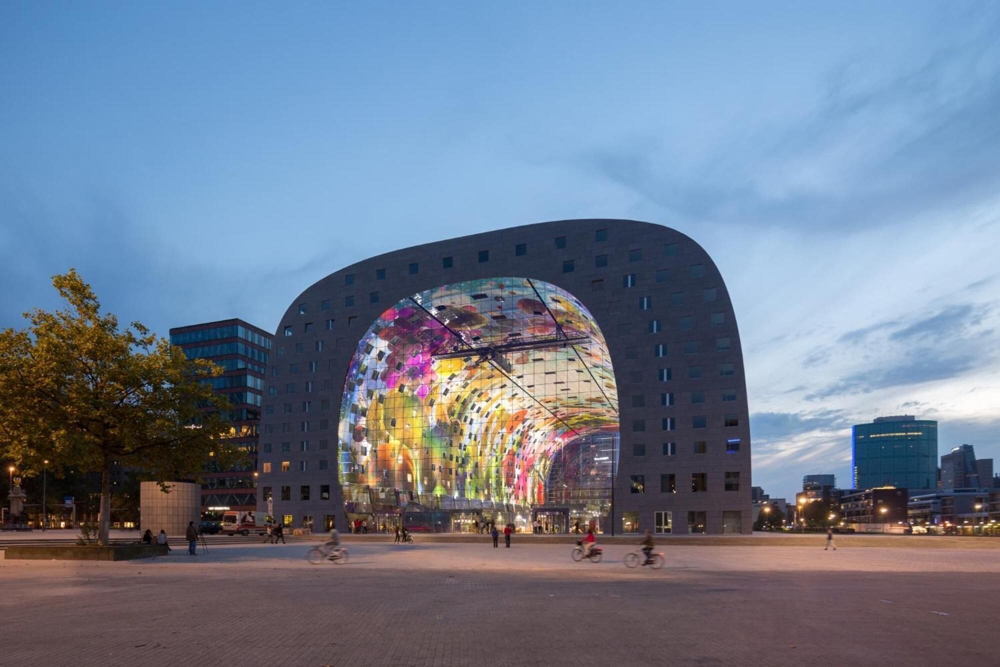 Un edificio moderno con una amplia fachada de vidrio y una entrada curva.