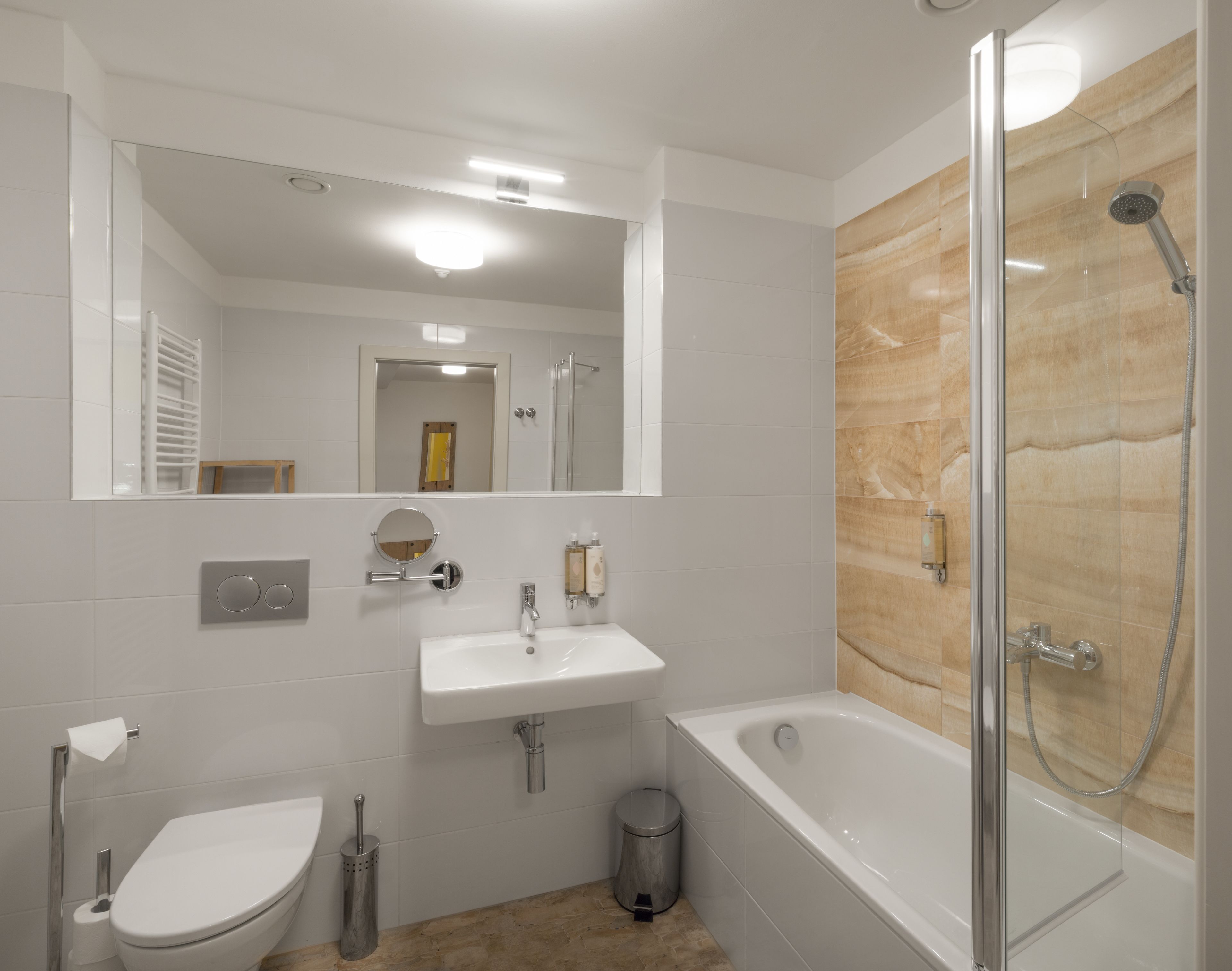 A modern bathroom with a toilet, sink, and bathtub.