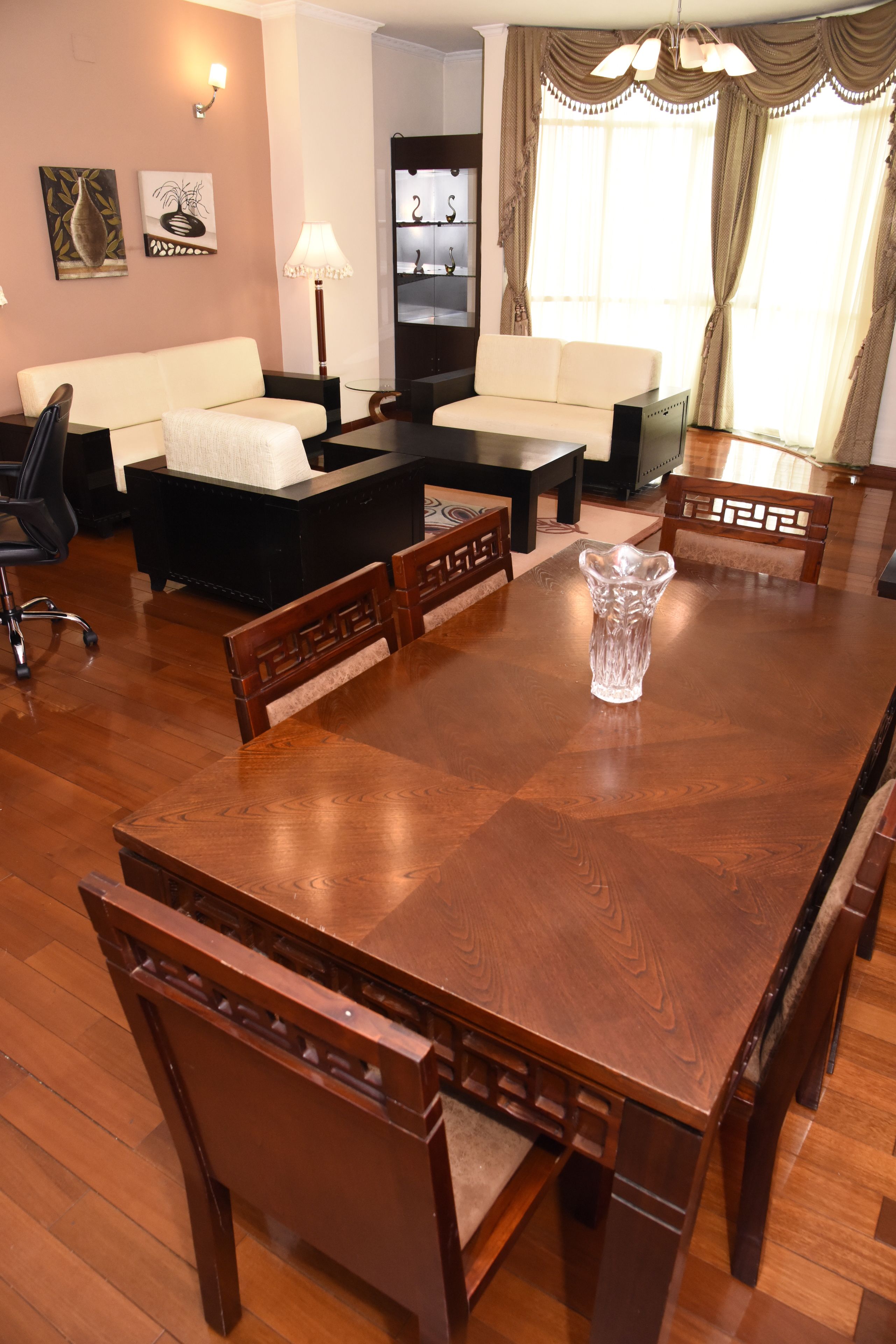 A dining area with a wooden table, chairs, and a vase.