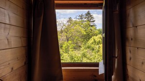 A wooden cabin interior with a window revealing a forested landscape. - Hotel Frýdl (Prague)