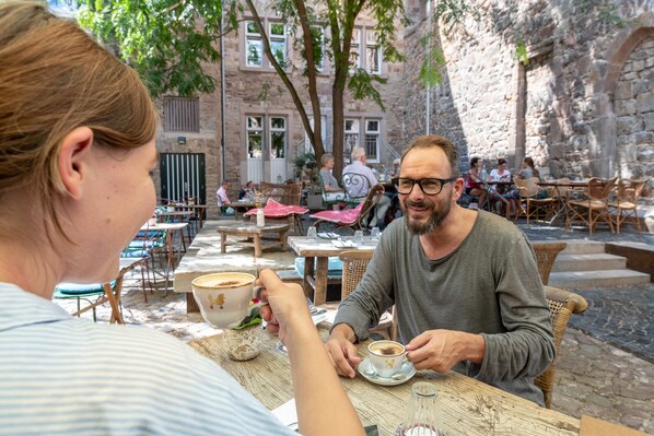 An outdoor café with stone walls and tables.