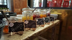 A food display with jars labeled 'Melone', 'Erdbere', and 'Prikose'.