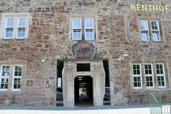 Un edificio de piedra con una entrada central, varias ventanas y el nombre "RENHOF" sobre la entrada.