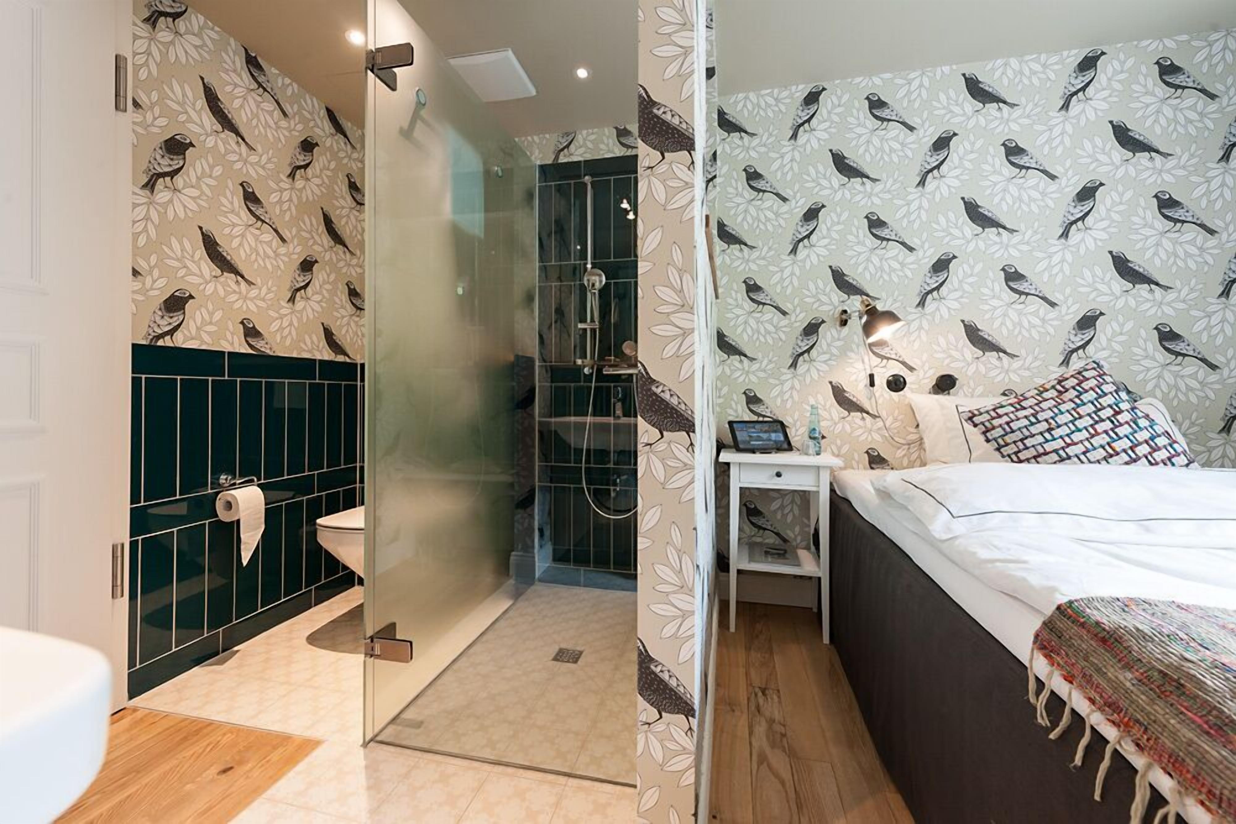 Un baño moderno con cabina de ducha de vidrio, inodoro y lavamanos.