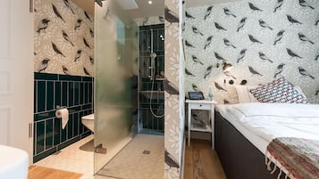 Un baño moderno con cabina de ducha de vidrio, inodoro y lavamanos.