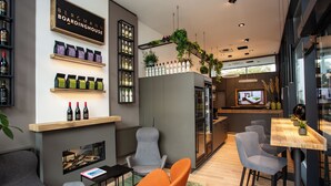 Een modern interieur met zitplaatsen, een open haard en een barruimte met flessen en planten.