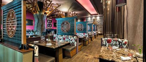 A restaurant with booths, a bar area, and a decorative ceiling.