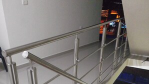 Una escalera metálica con barandilla que baja a un nivel inferior.