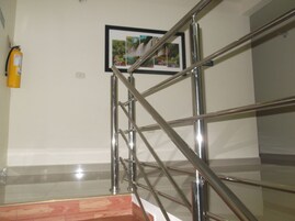 Una escalera con barandillas de metal y un extintor de incendios fijado a la pared.