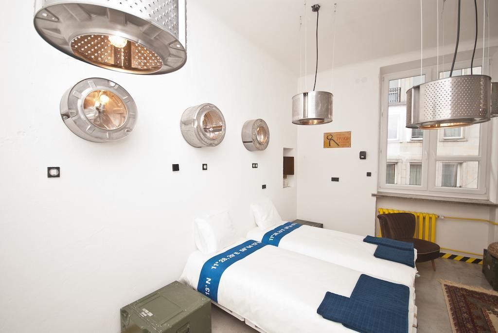 Una habitación de hotel con cama, una silla, un escritorio y una ventana.