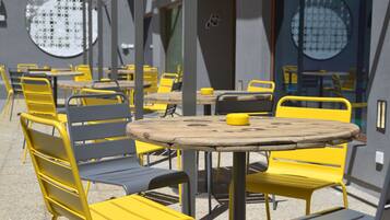 Une série de tables et de chaises d’extérieur au design moderne, disposées en ligne le long d’une allée.