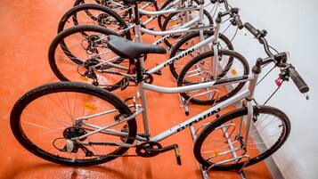 A row of bicycles parked indoors on an orange floor.