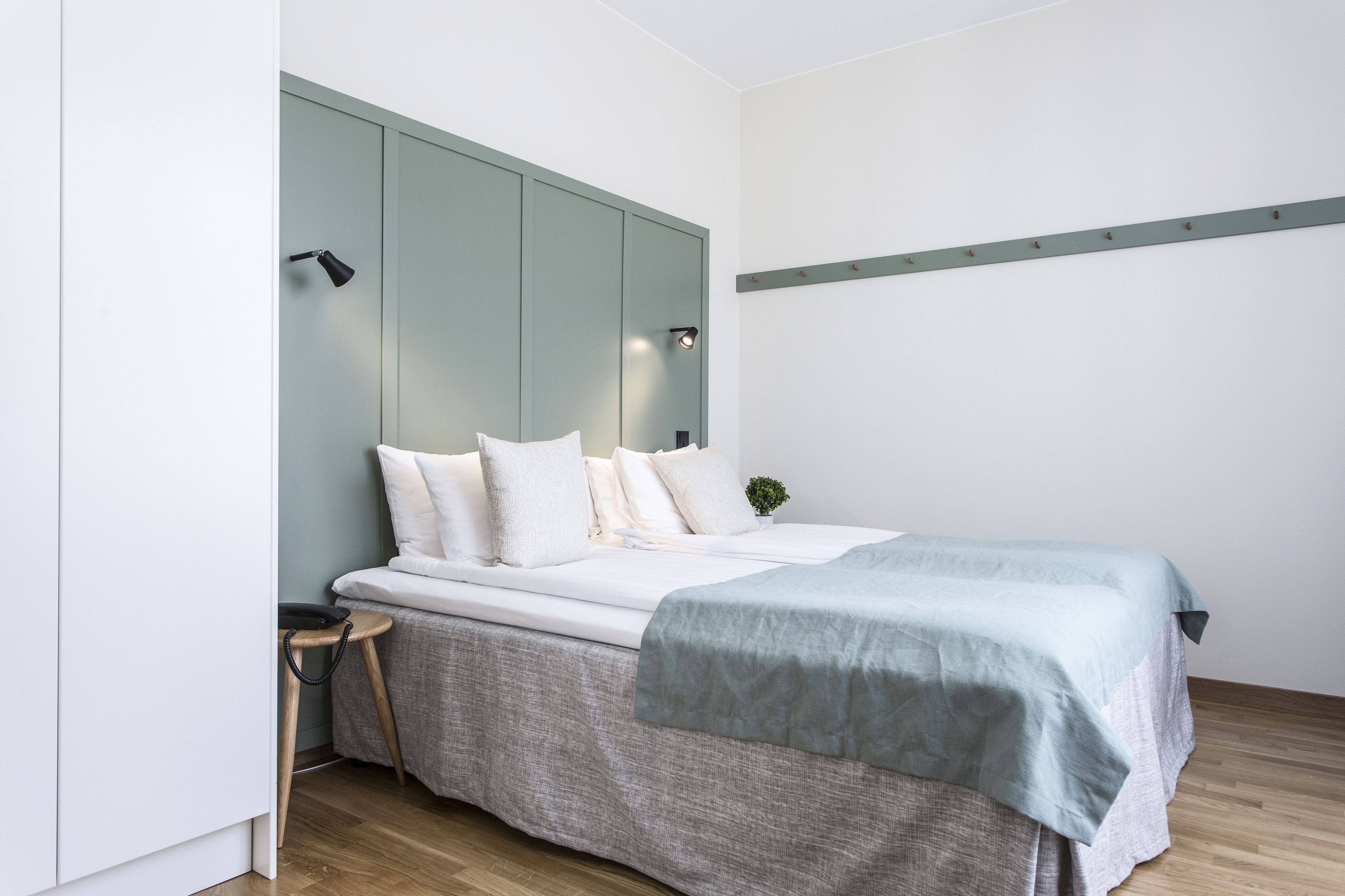 A modern bedroom with a bed, bedside table, and a nightstand.