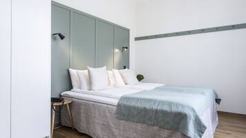 A modern bedroom with a bed, bedside table, and a nightstand.