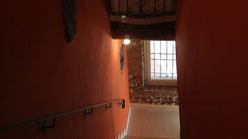 Un escalier avec une rampe en métal, une porte en haut et une fenêtre en bas.