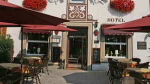A hotel named "KRONE" with red flower boxes, outdoor seating, and a sign indicating "Hotel." - Hotel Krone Rüdesheim (Ruedesheim am Rhein)