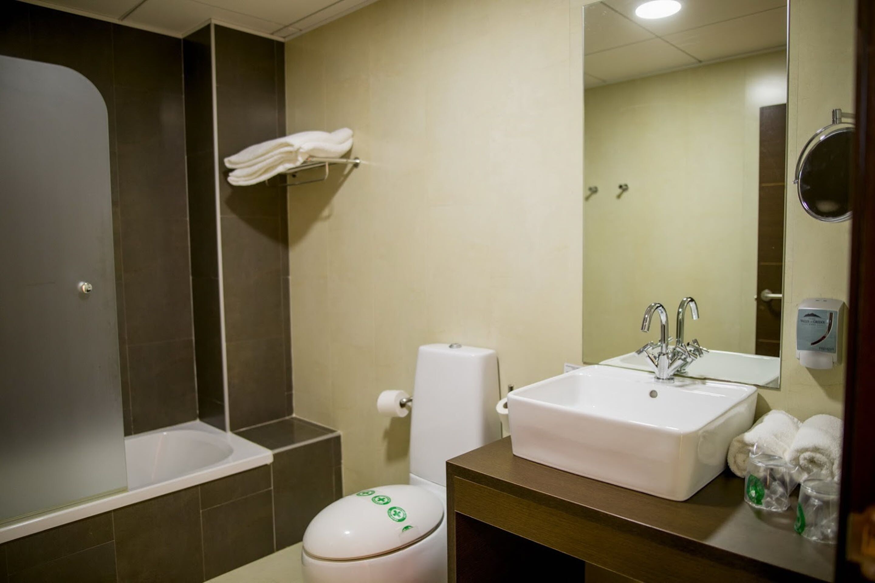 Een badkamer met een bad, toilet, wastafel en spiegel.