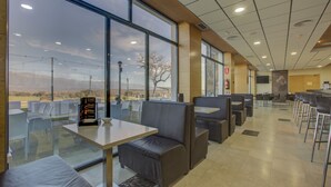 Un restaurante con ventanas amplias, cabinas y piso de baldosas.