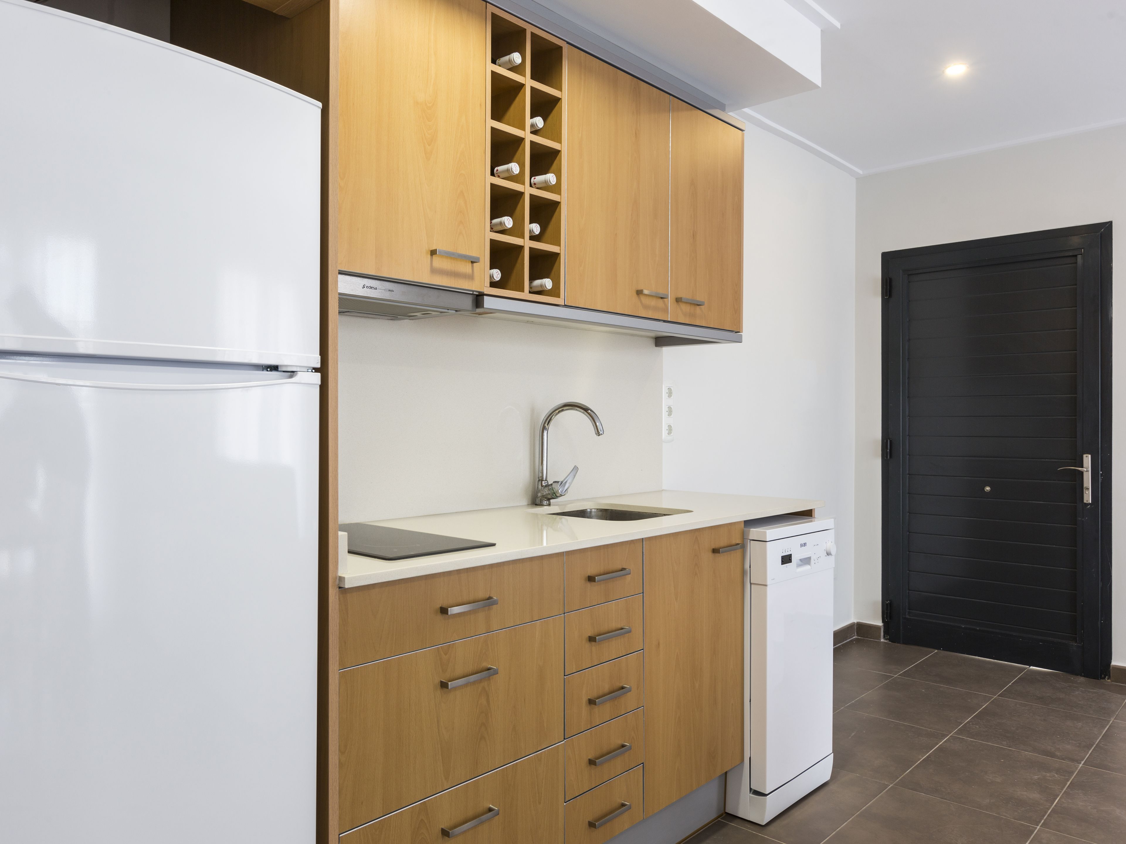 A modern kitchen with wooden cabinets, a stainless steel sink, and a dishwasher.