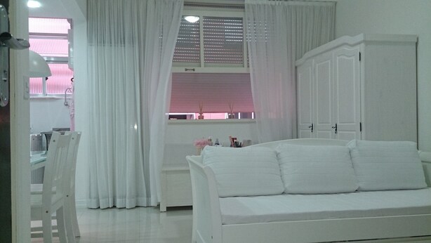 A white room with a bed, a desk, and a window with curtains. - Estúdio Praia do Flamengo - 1018 (Rio de Janeiro)