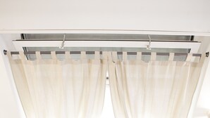 A modern, minimalist room with a staircase, a radiator, and sheer curtains. - Alessia's Flat - Mac Mahon (Milan)