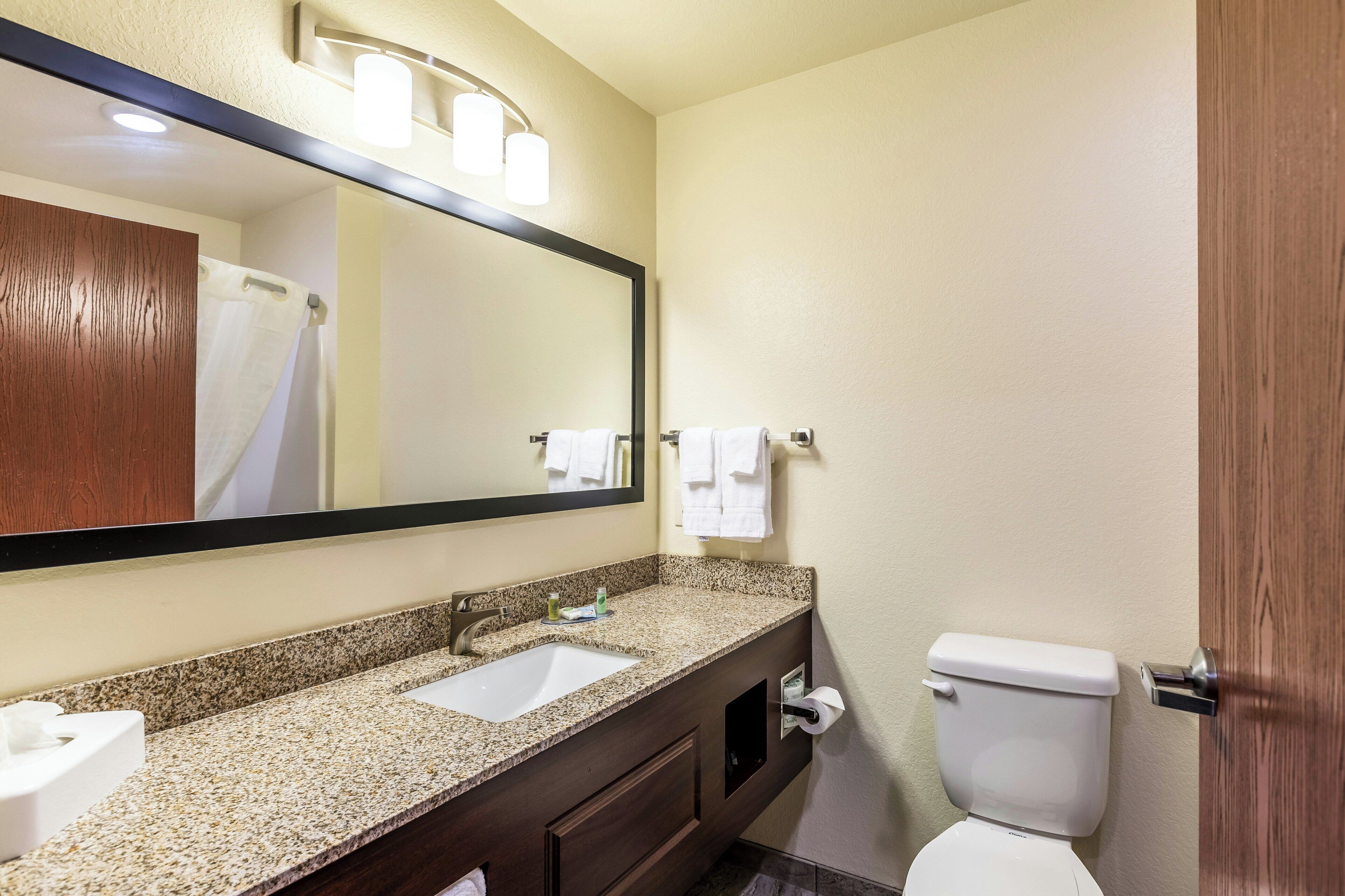 Kylpyhuone, jossa on pesuallas, peili ja wc.