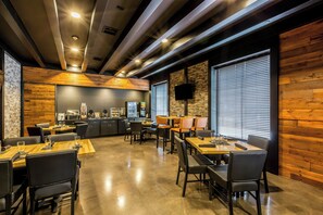 Un restaurante moderno con detalles de madera, una zona de cocina y un televisor de pantalla plana.