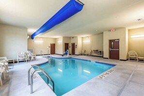 Una piscina interior con borde azul, un respiradero en el techo azul y un cartel que indica que no se permite bucear.