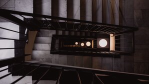 A modern staircase with a metal railing and a circular light fixture at the top. - Select Sol (Madrid)