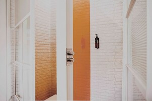 Ein Flur mit weißen Ziegelwänden und einem orangefarbenen Streifen in der Mitte.