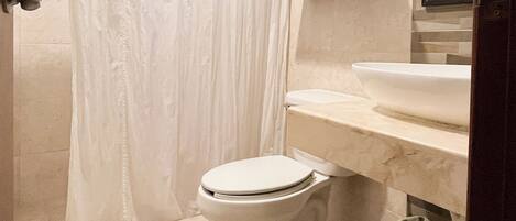 A bathroom with a toilet, a sink, a shower curtain, and a towel rack.