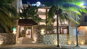 A hotel entrance with a stone facade, palm trees, and a sign that reads 'Grespo Beach.' - Progreso Beach Hotel (Progreso)