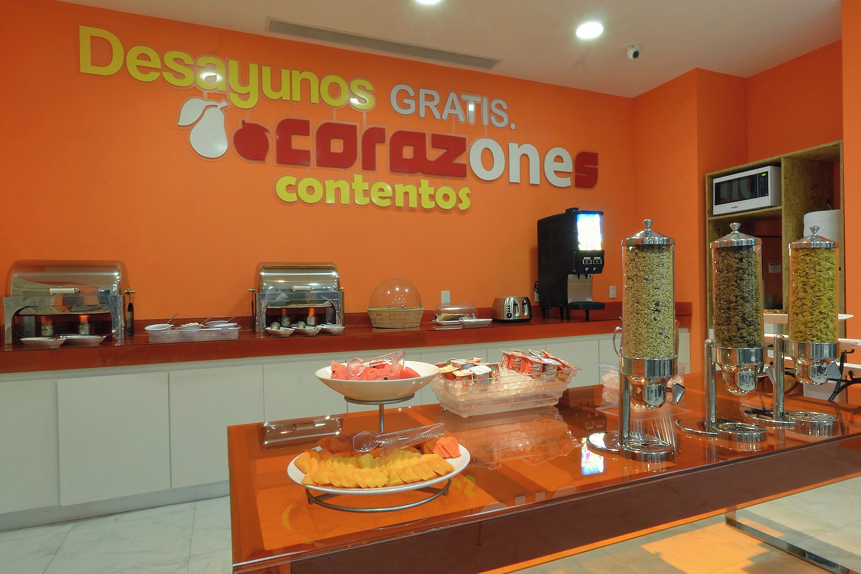 A buffet area with a sign reading "Desayunos gratis. corazónones contenidos".