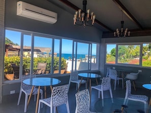 Enjoy a room with a sea view, round tables, and comfortable seating, perfect for relaxing.