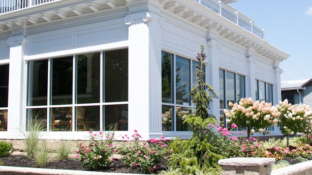 A large, white, two-story house with a balcony, large windows, and a well-maintained garden. - Wishmaker House B&B (Bellville)