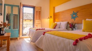 Une chambre d’hôtel avec deux lits, une tête de lit en bois, un élément décoratif mural et une vue sur l’extérieur.